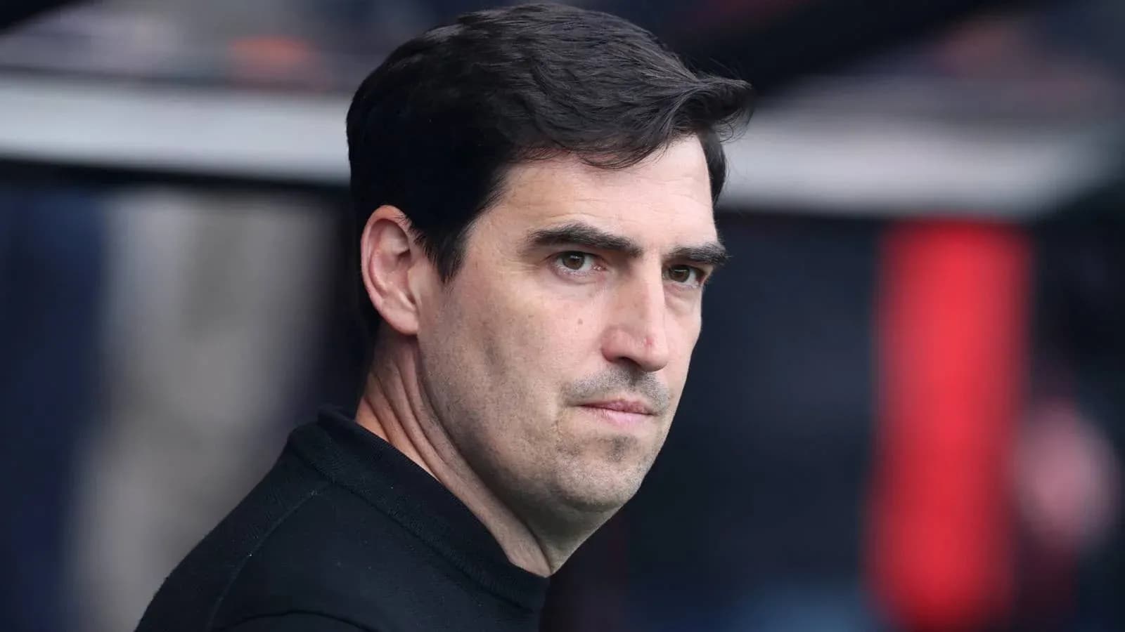 Entrenador observando el partido desde el banquillo