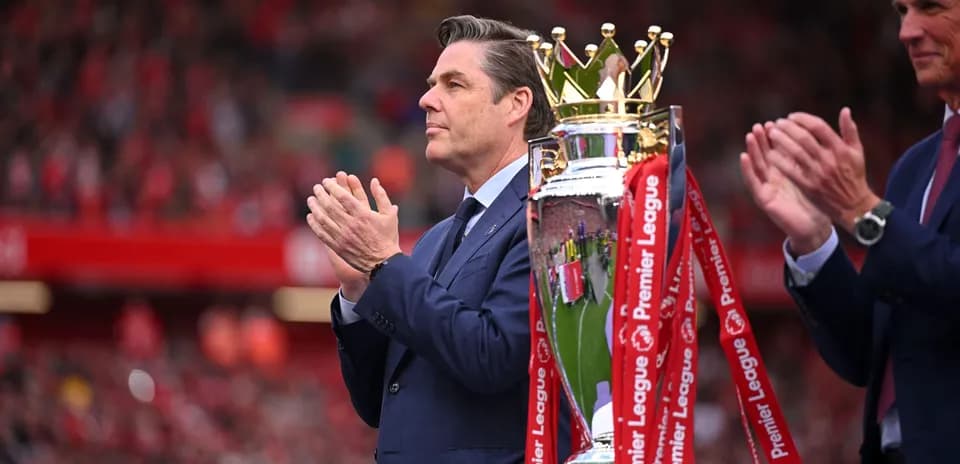 Persona aplaudiendo junto a trofeo de Premier League
