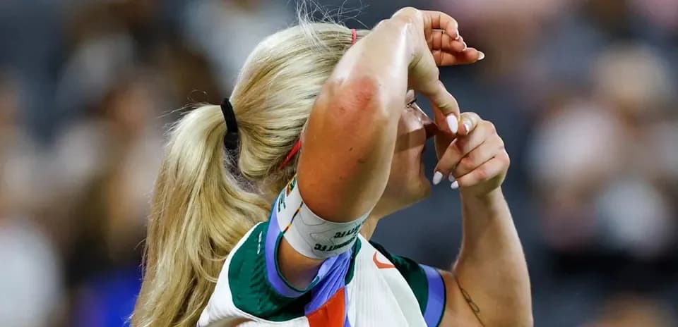 Jugadora de tenis tocándose la frente en la cancha