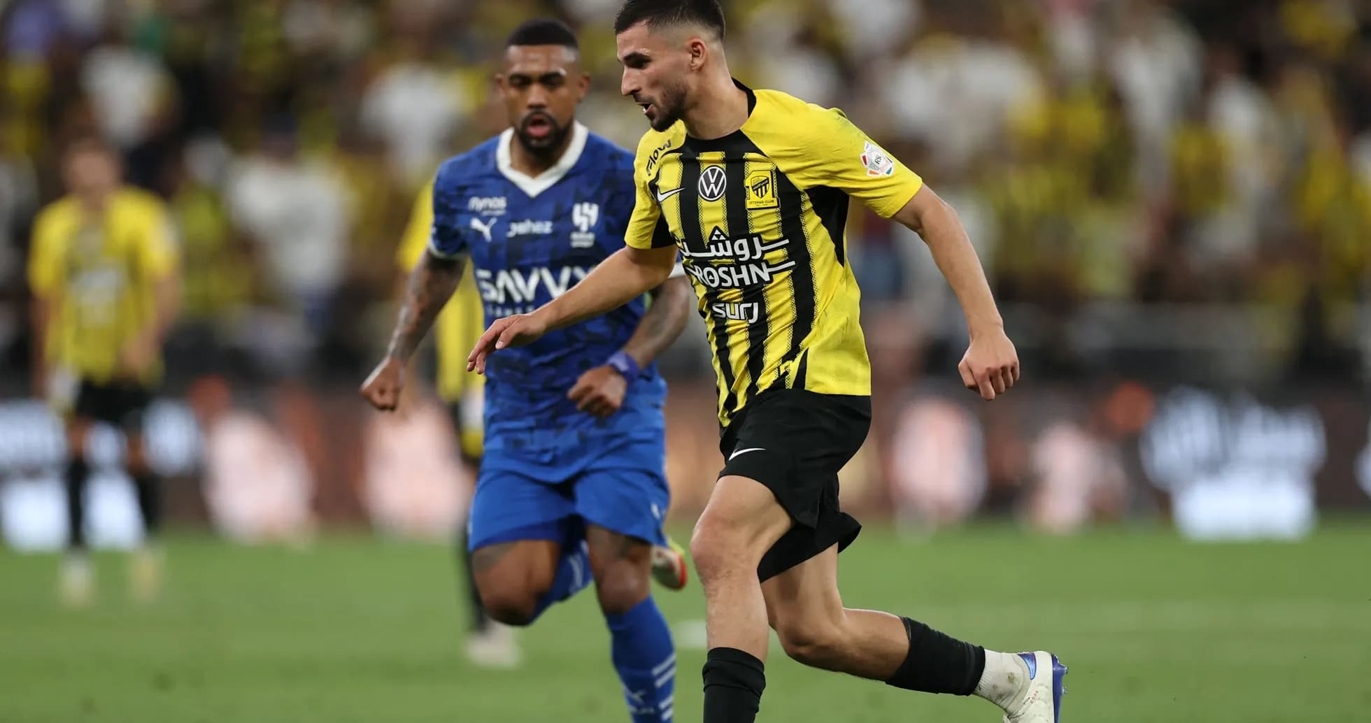 Jugador de Ittihad corriendo con el balón durante partido Jugador de Ittihad corriendo con el balón durante partido