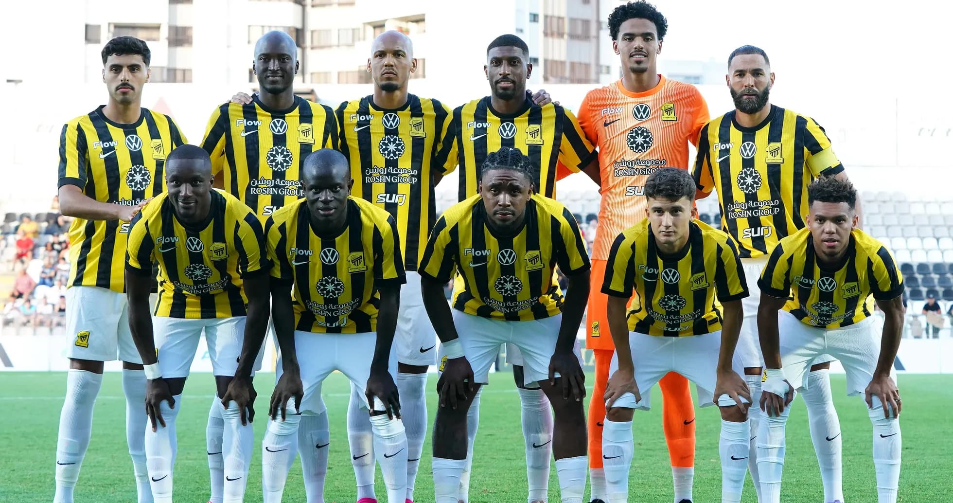 Equipo de fútbol posando en uniforme amarillo y negro Equipo de fútbol posando en uniforme amarillo y negro