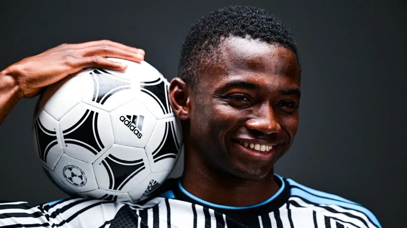 Jugador sosteniendo un balón de fútbol con una mano Jugador sosteniendo un balón de fútbol con una mano