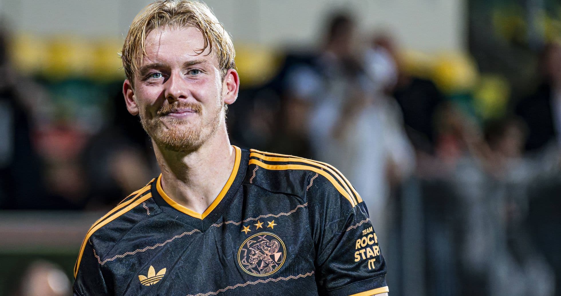 Jugador de Ajax sonriendo en el campo de fútbol Jugador de Ajax sonriendo en el campo de fútbol