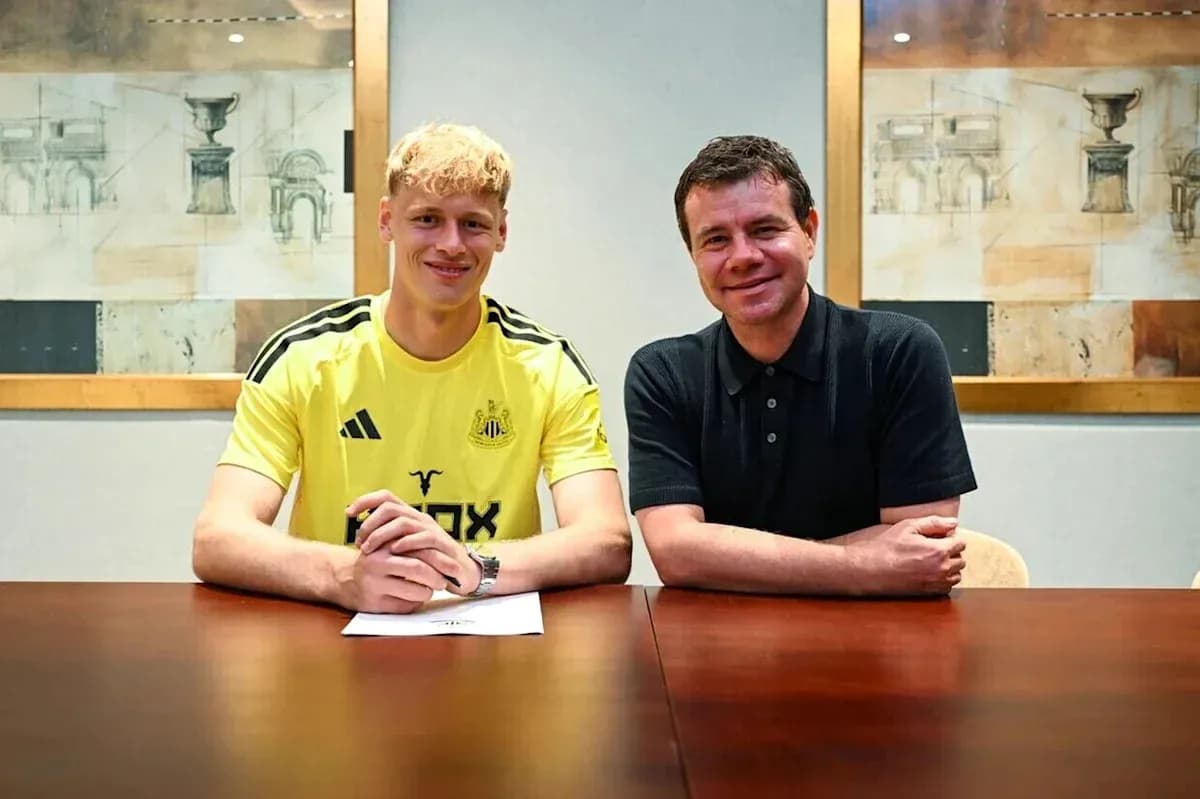 Jugador de Newcastle firmando contrato con directivo Jugador de Newcastle firmando contrato con directivo