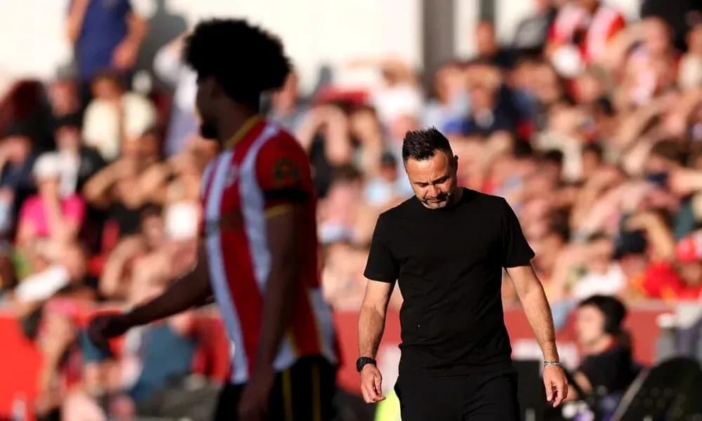 Entrenador caminando con expresión seria durante partido Entrenador caminando con expresión seria durante partido
