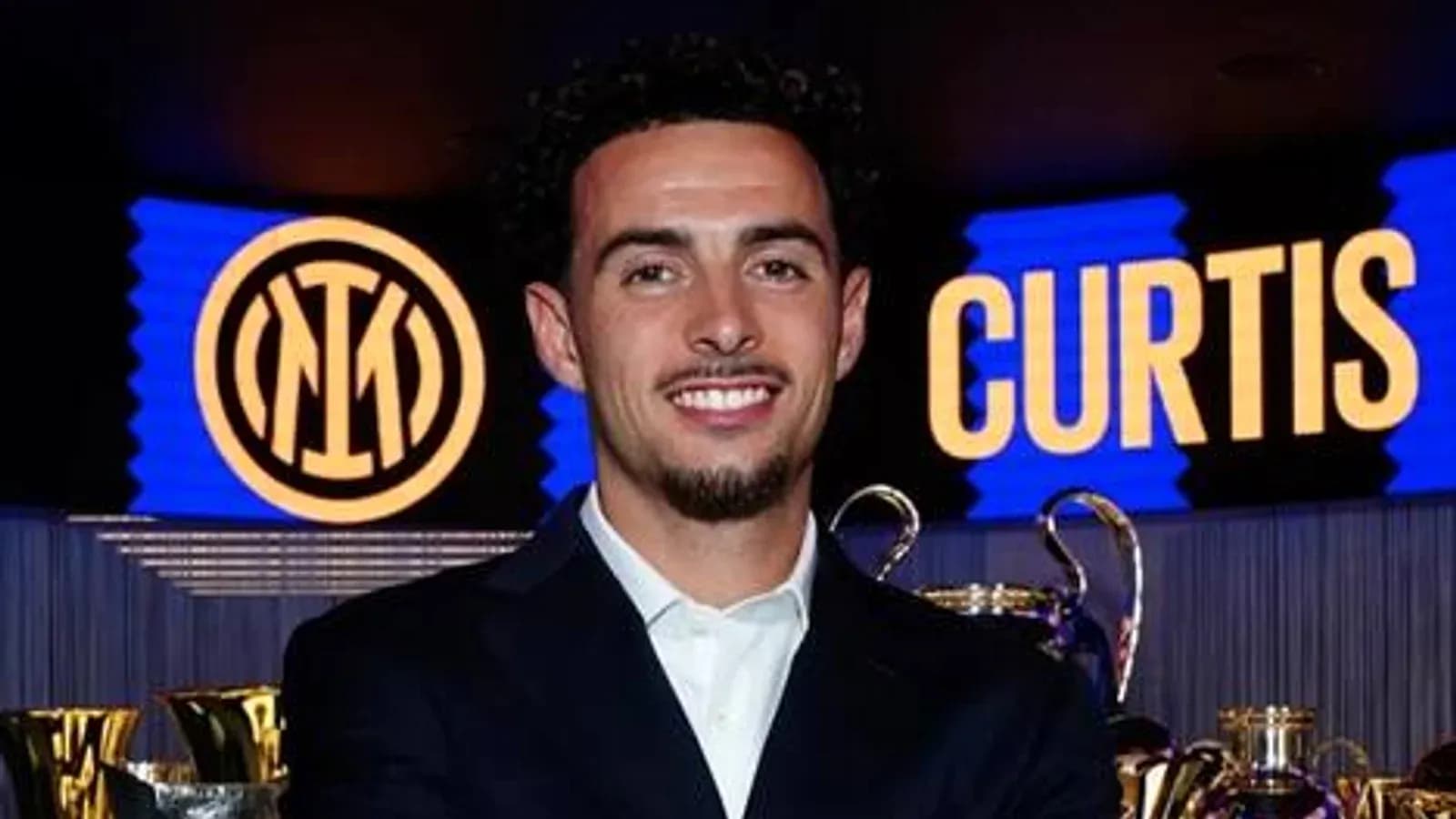 Jugador sonriente junto a trofeos de Inter de Milán Jugador sonriente junto a trofeos de Inter de Milán