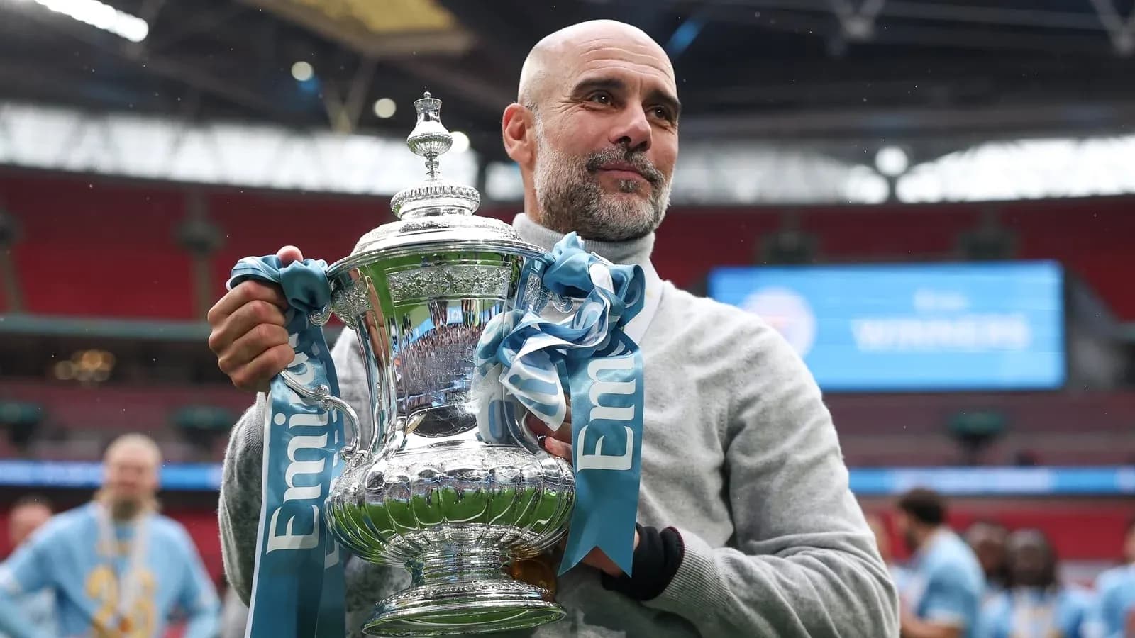 Entrenador sosteniendo trofeo en el estadio Wembley Entrenador sosteniendo trofeo en el estadio Wembley