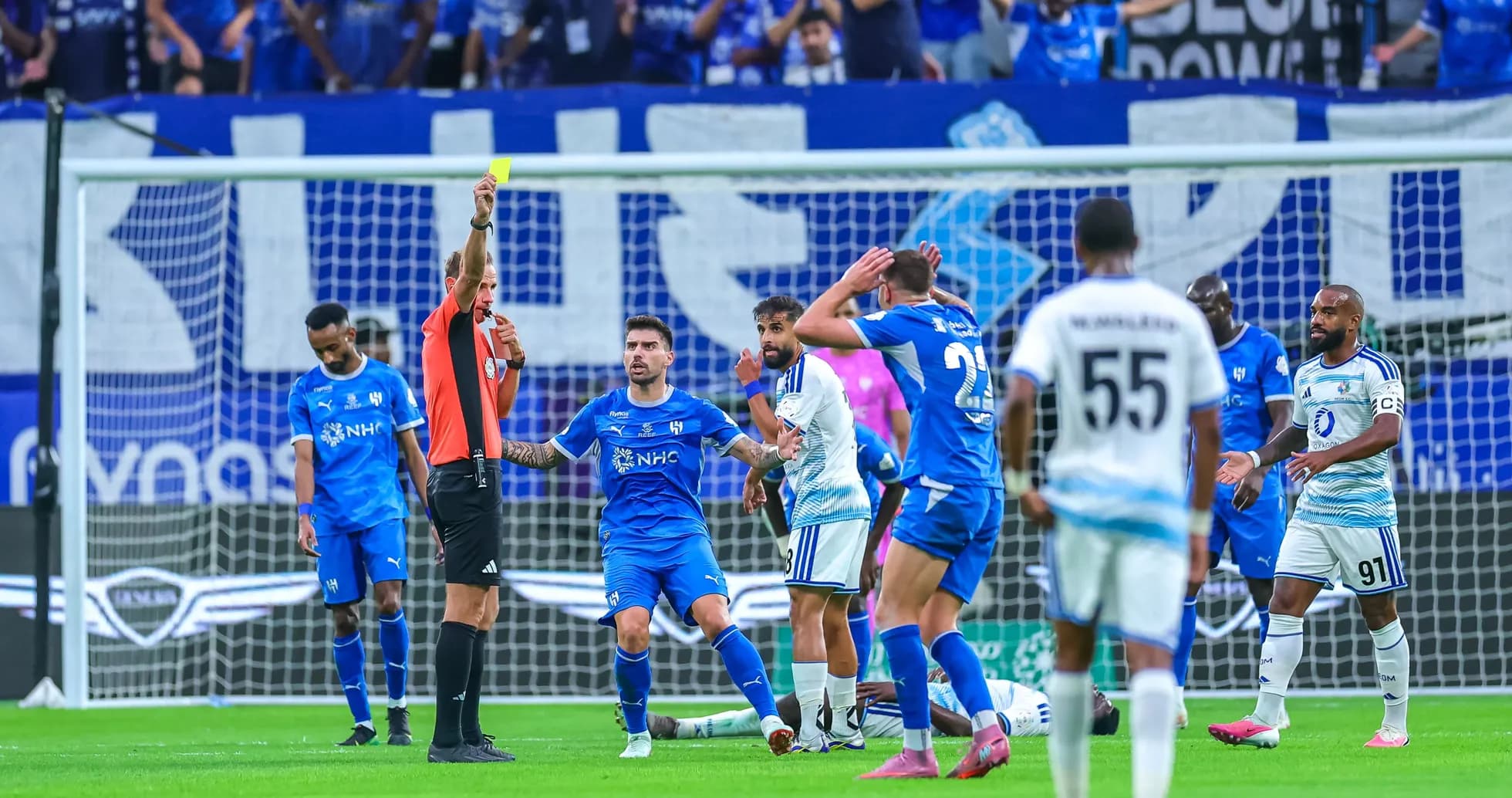 Árbitro mostrando tarjeta amarilla a jugador durante partido Árbitro mostrando tarjeta amarilla a jugador durante partido