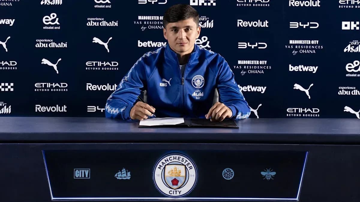 Jugador firmando contrato en mesa de prensa Jugador firmando contrato en mesa de prensa