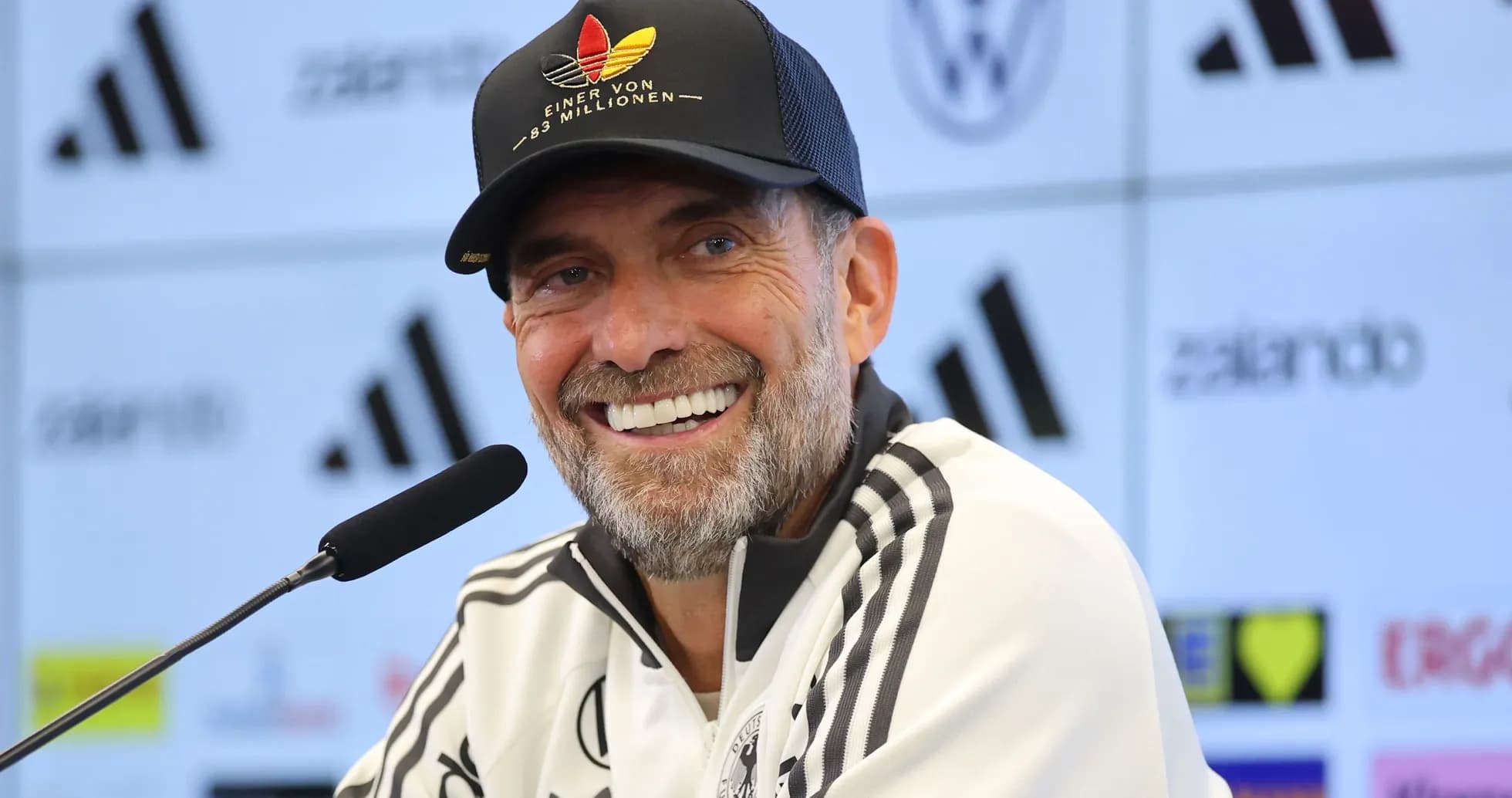 Entrenador sonriendo en conferencia de prensa Entrenador sonriendo en conferencia de prensa
