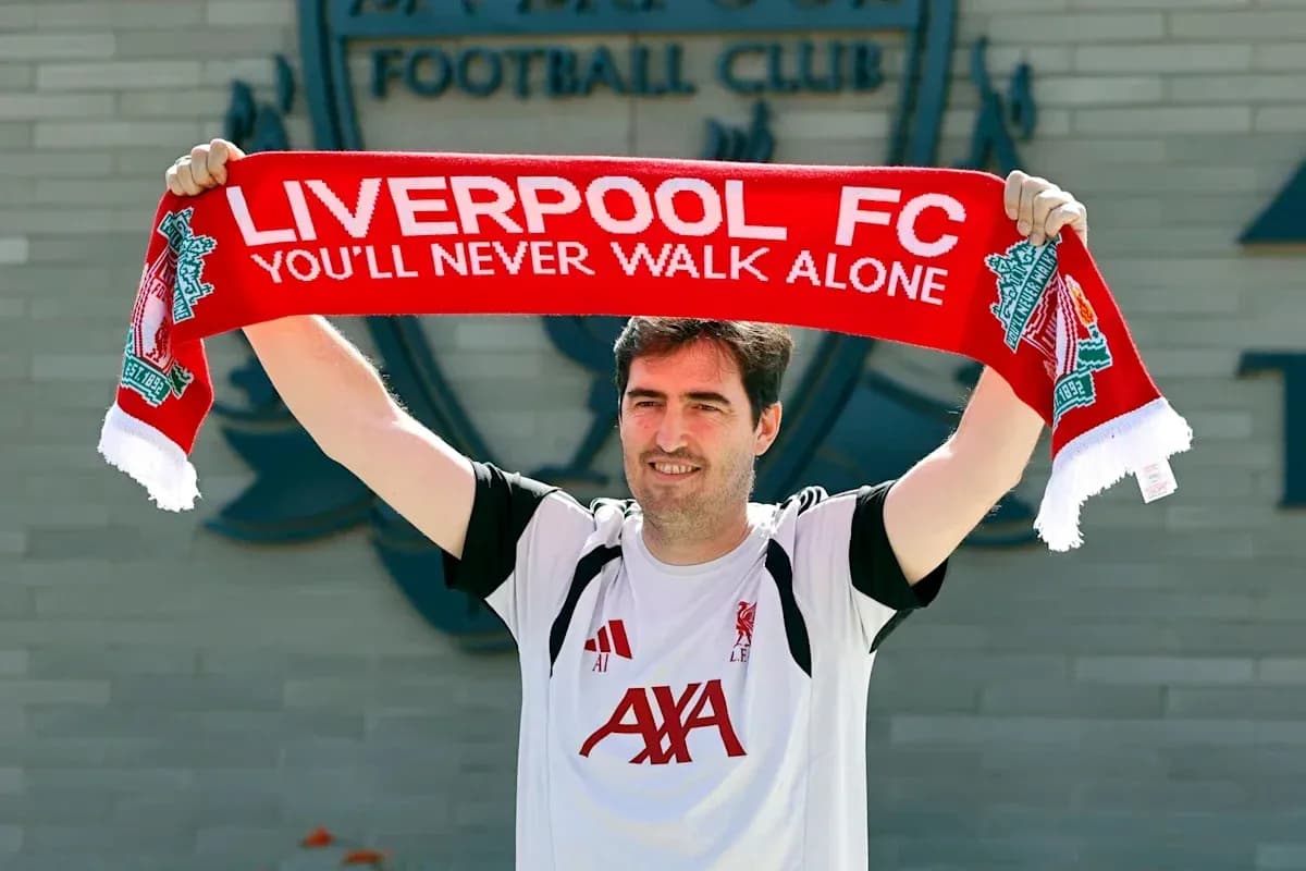 Persona sosteniendo bufanda de Liverpool FC Persona sosteniendo bufanda de Liverpool FC