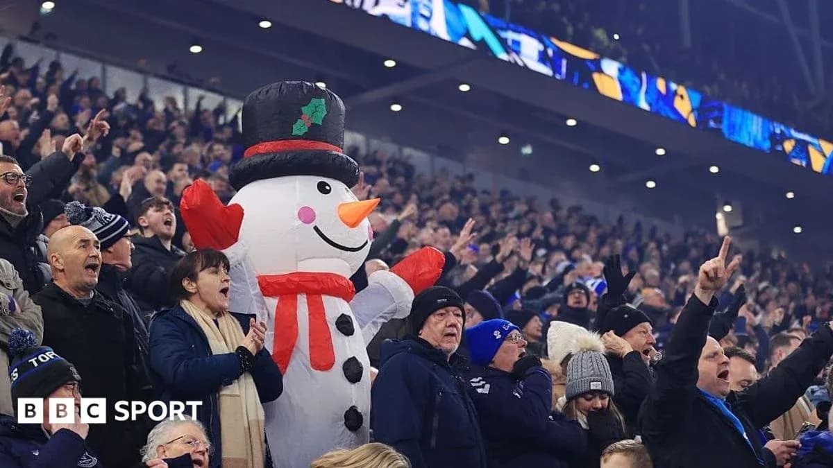 A large snowman inflatable among cheering fans A large snowman inflatable among cheering fans