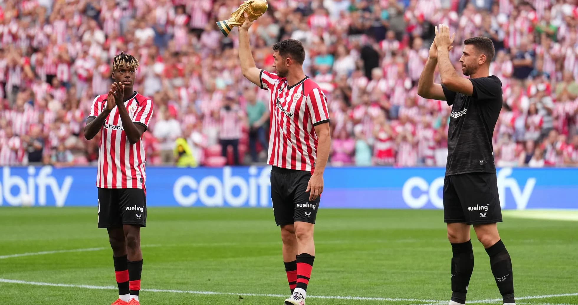 Jugadores de Athletic Club celebrando con trofeo en el campo Jugadores de Athletic Club celebrando con trofeo en el campo