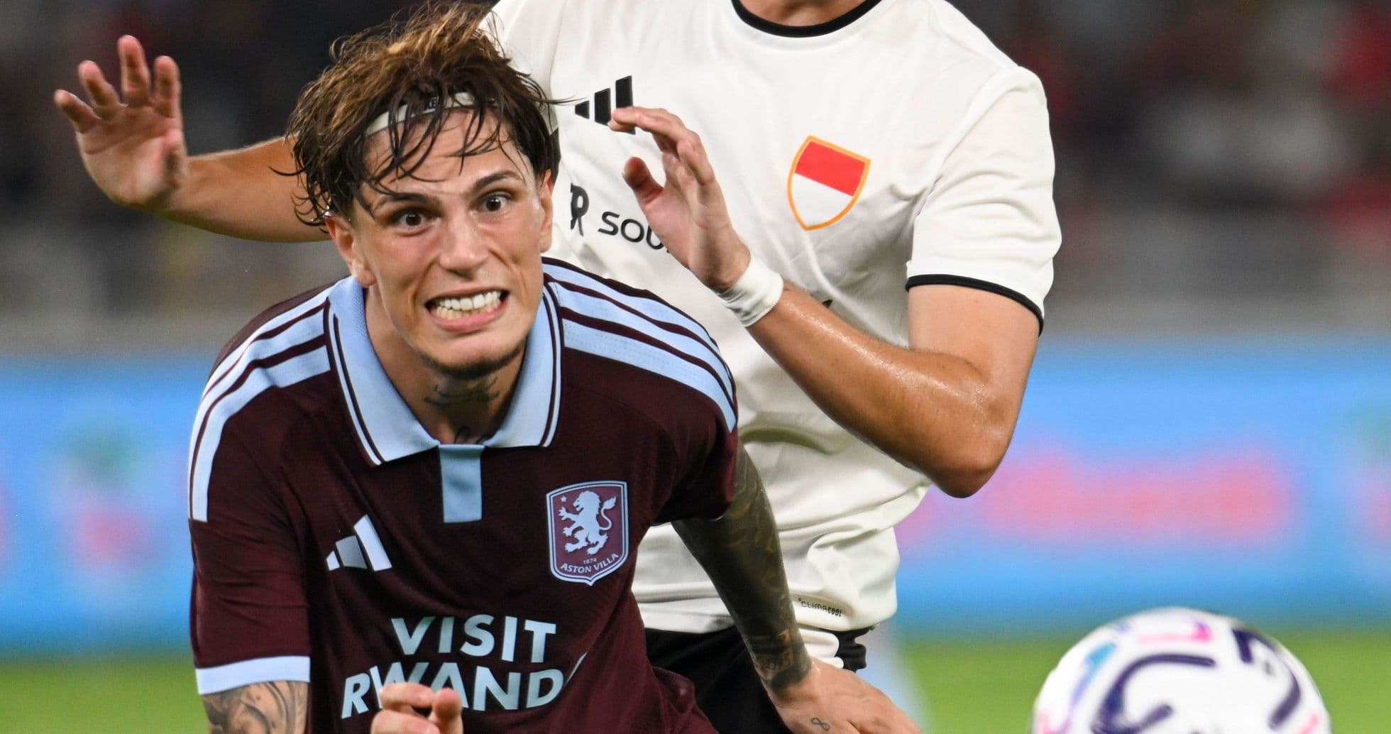 Jugador de Aston Villa siendo marcado por adversario Jugador de Aston Villa siendo marcado por adversario