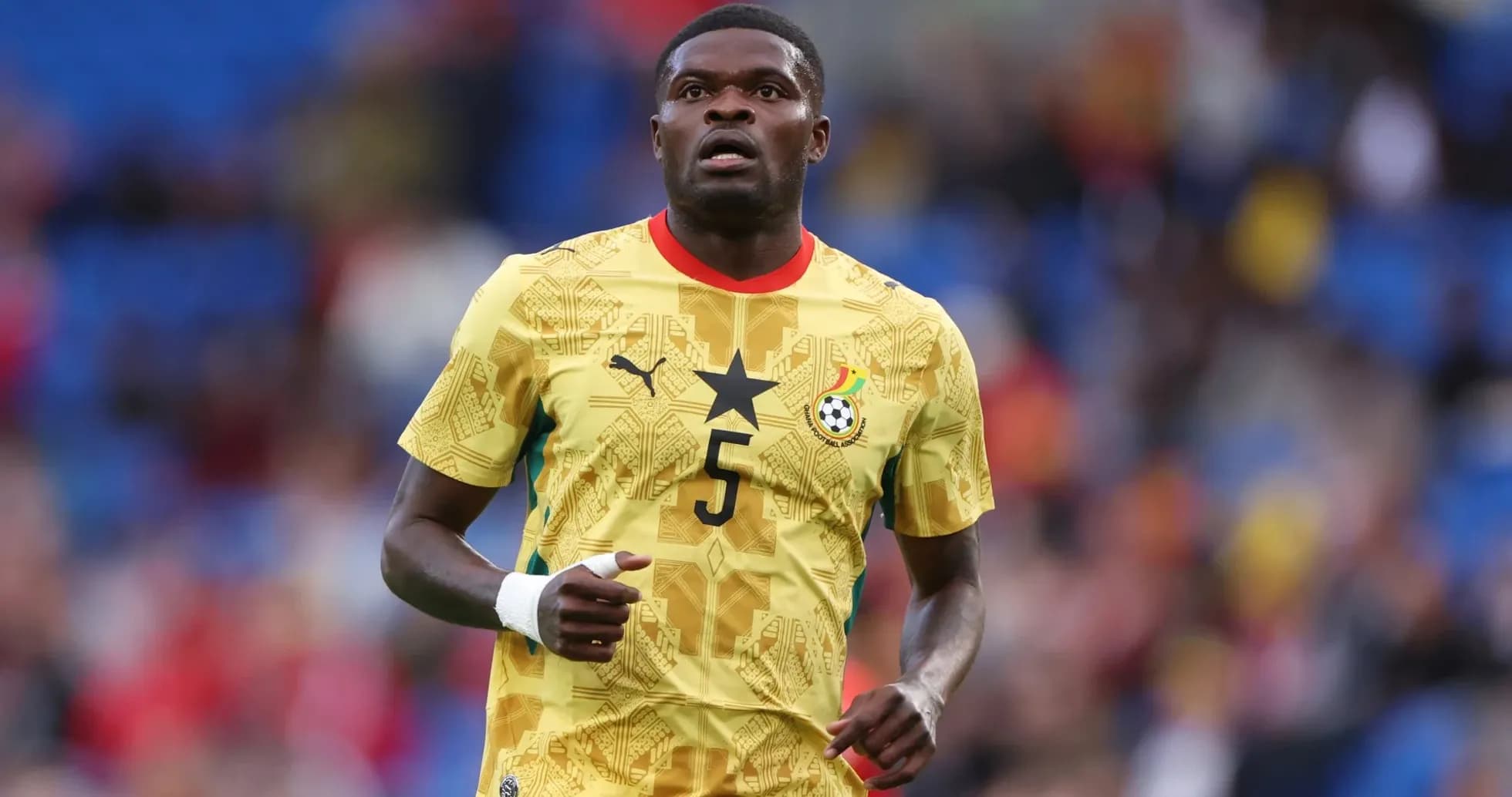 Jugador de Ghana corriendo en camiseta amarilla Jugador de Ghana corriendo en camiseta amarilla