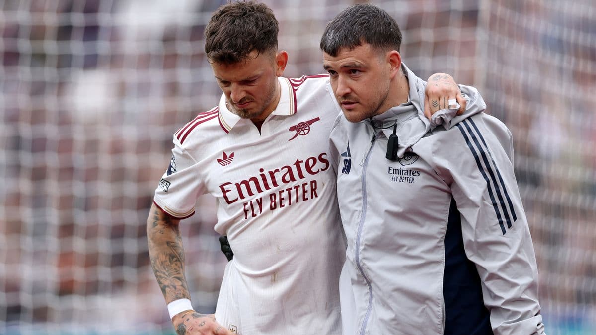 Jugador de Arsenal siendo ayudado por personal médico Jugador de Arsenal siendo ayudado por personal médico