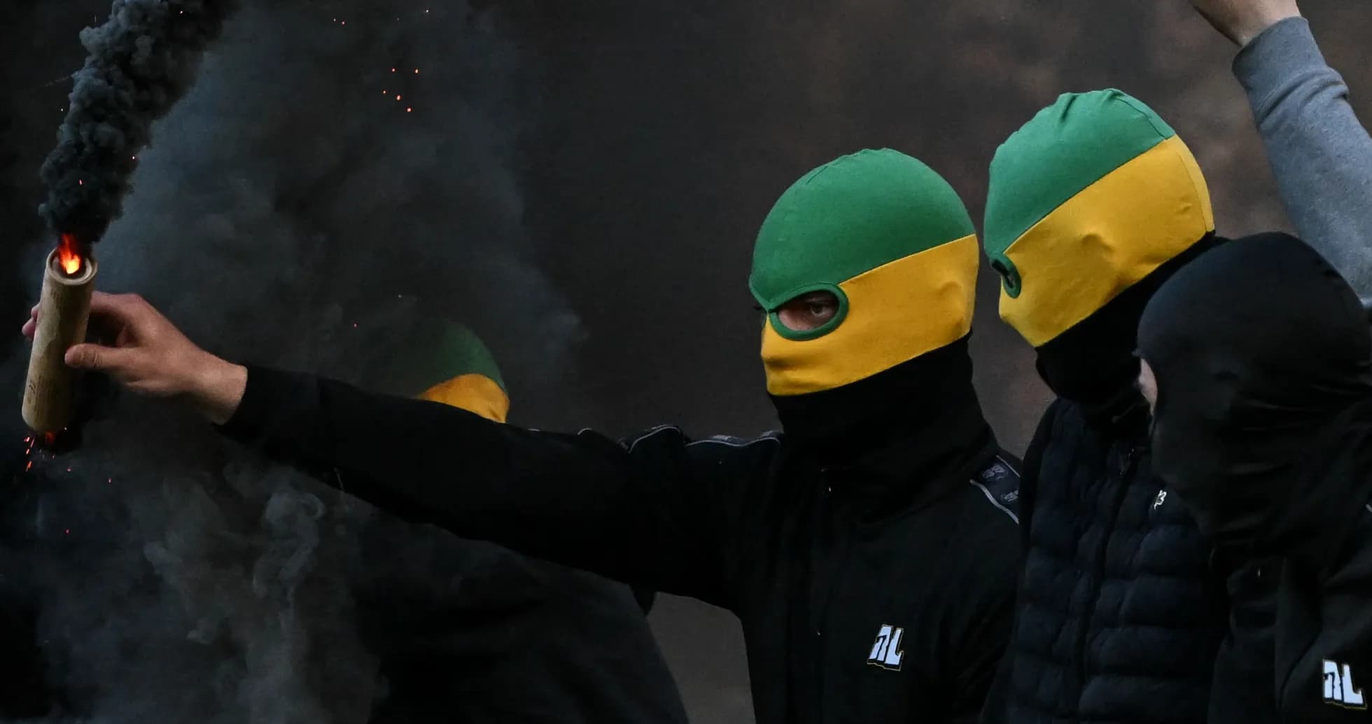Grupo de personas con máscaras encendiendo un artefacto Grupo de personas con máscaras encendiendo un artefacto