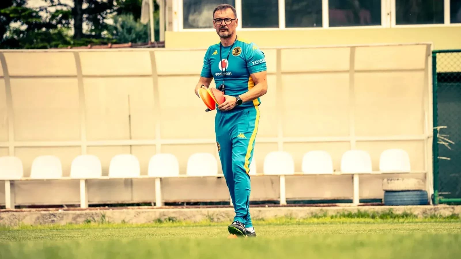 Entrenador sosteniendo conos en el campo de entrenamiento Entrenador sosteniendo conos en el campo de entrenamiento