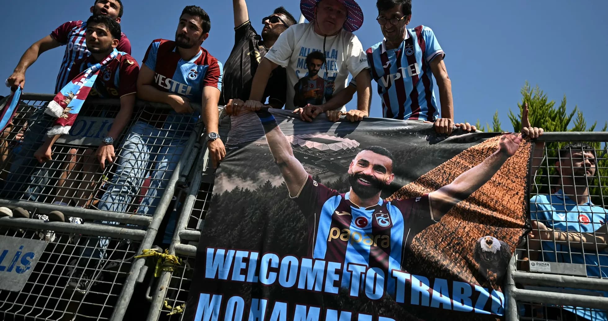 Aficionados con pancarta dando la bienvenida a jugador Aficionados con pancarta dando la bienvenida a jugador