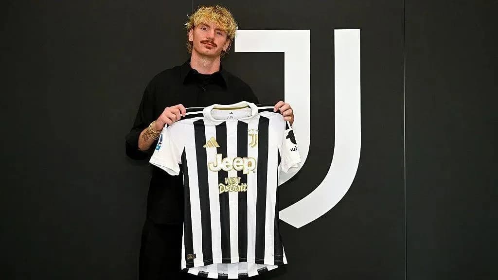 Jugador mostrando camiseta de Juventus en presentación Jugador mostrando camiseta de Juventus en presentación
