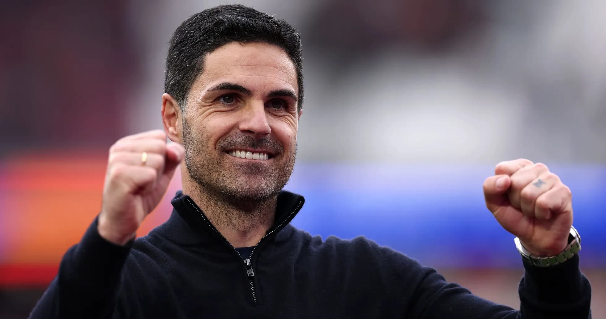 Entrenador sonriendo y levantando los puños en celebración Entrenador sonriendo y levantando los puños en celebración