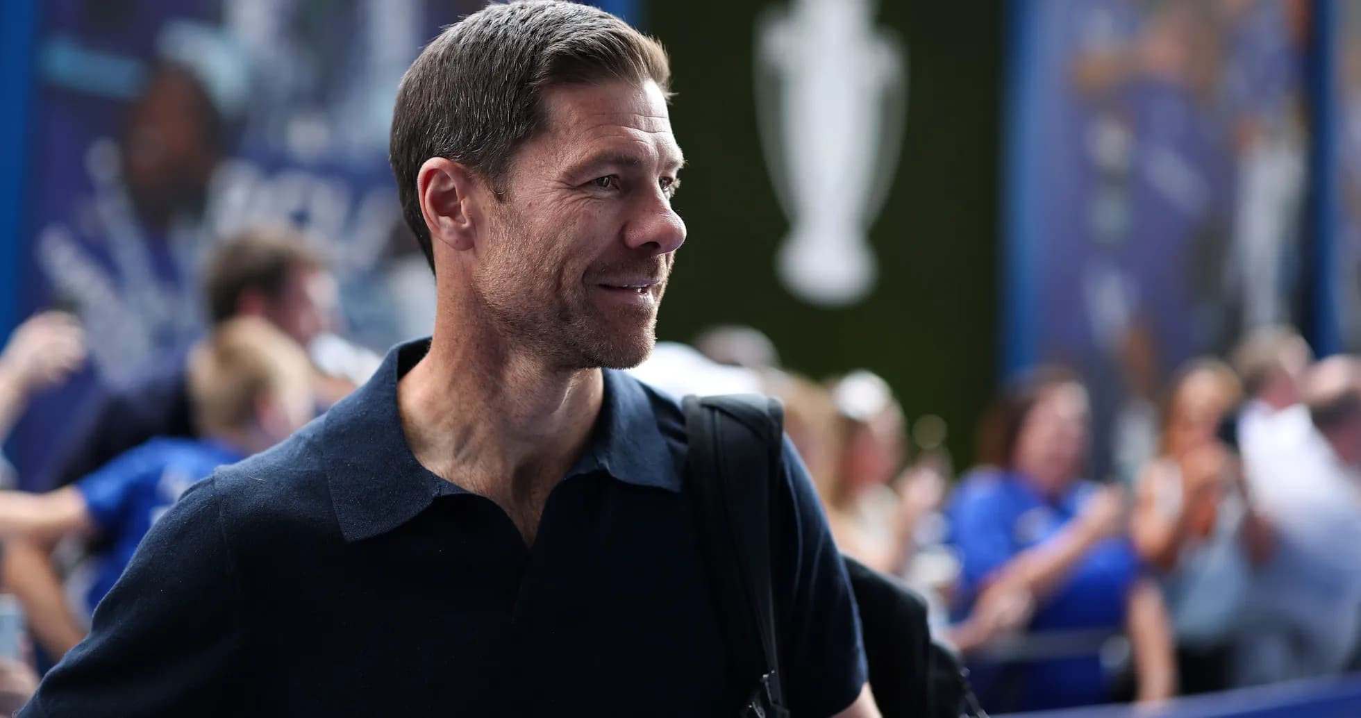 Hombre sonriendo en evento deportivo con público Hombre sonriendo en evento deportivo con público