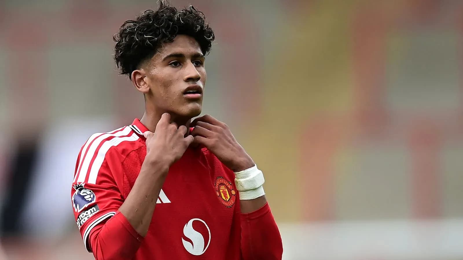Jugador de Manchester United ajustándose el cuello del uniforme Jugador de Manchester United ajustándose el cuello del uniforme
