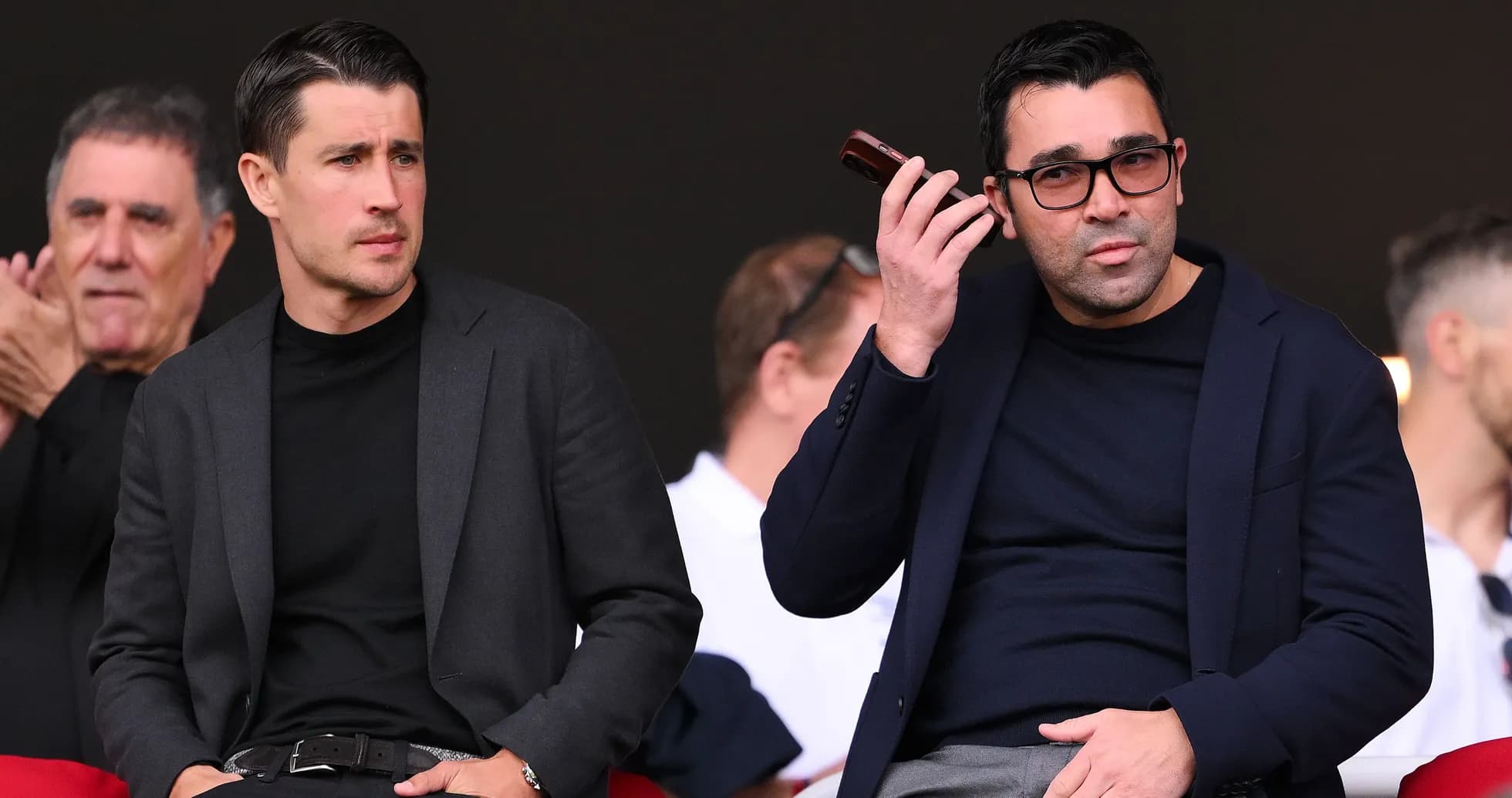 Dos hombres observando un evento deportivo desde la grada Dos hombres observando un evento deportivo desde la grada