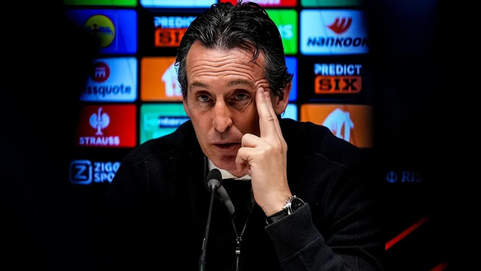 Entrenador en conferencia de prensa señalando su cabeza Entrenador en conferencia de prensa señalando su cabeza