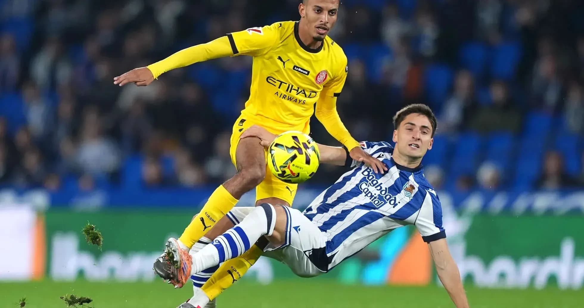 Jugador de Girona desafiando a un jugador de Real Sociedad Jugador de Girona desafiando a un jugador de Real Sociedad